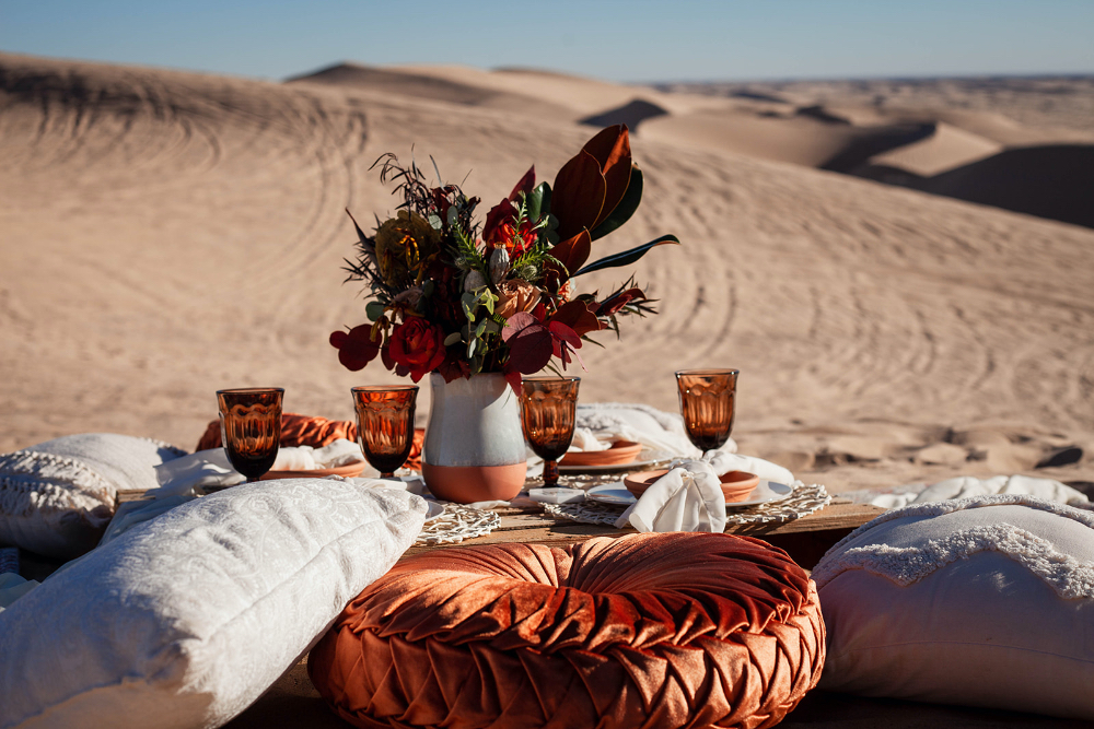 Pillow seating and picnic with florals in intimate desert elopement setup
