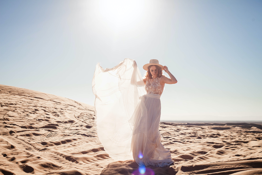 Bride with flowy dress with the sun behind her