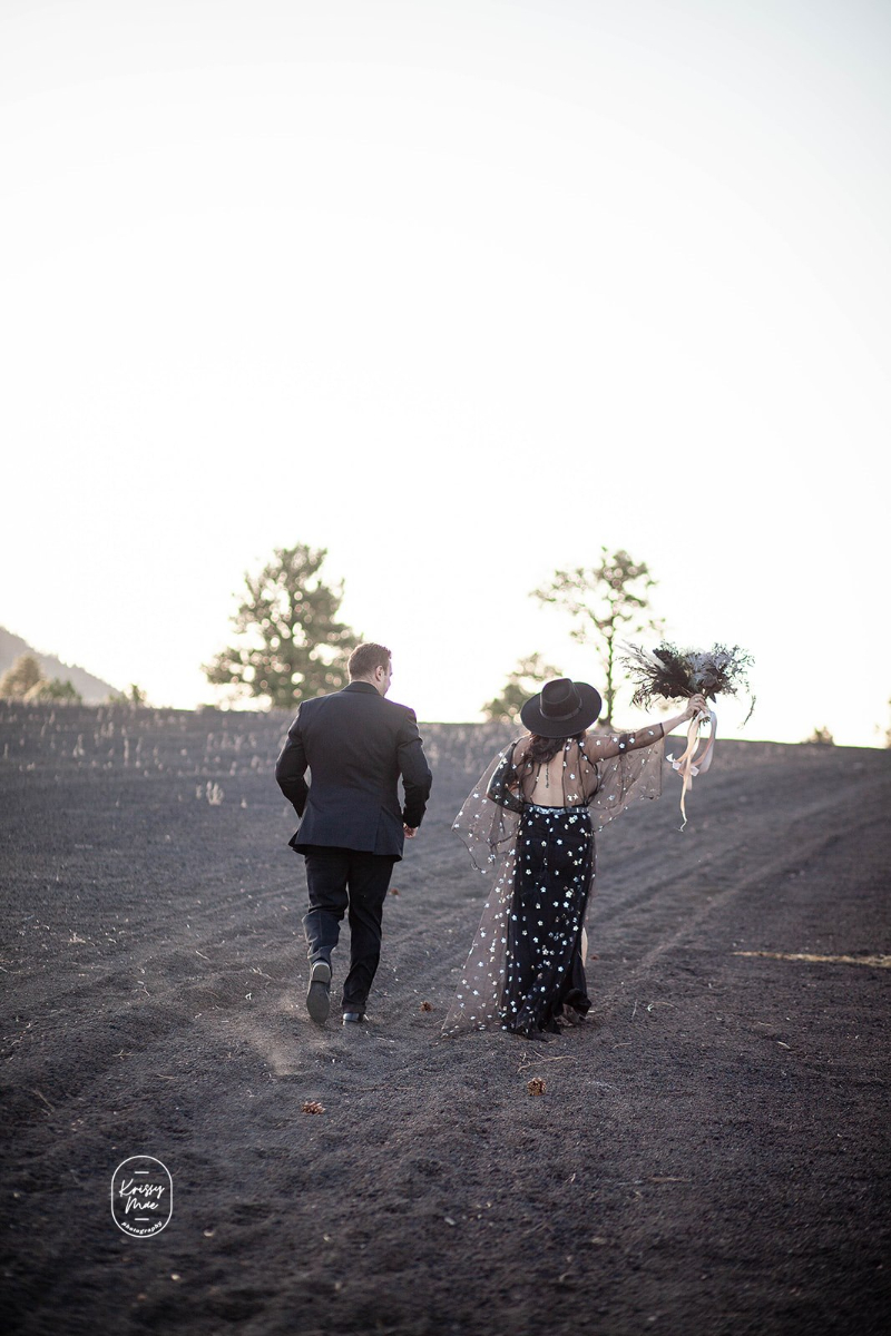 Groom dances with bride in black dress at Arizona desert elopement