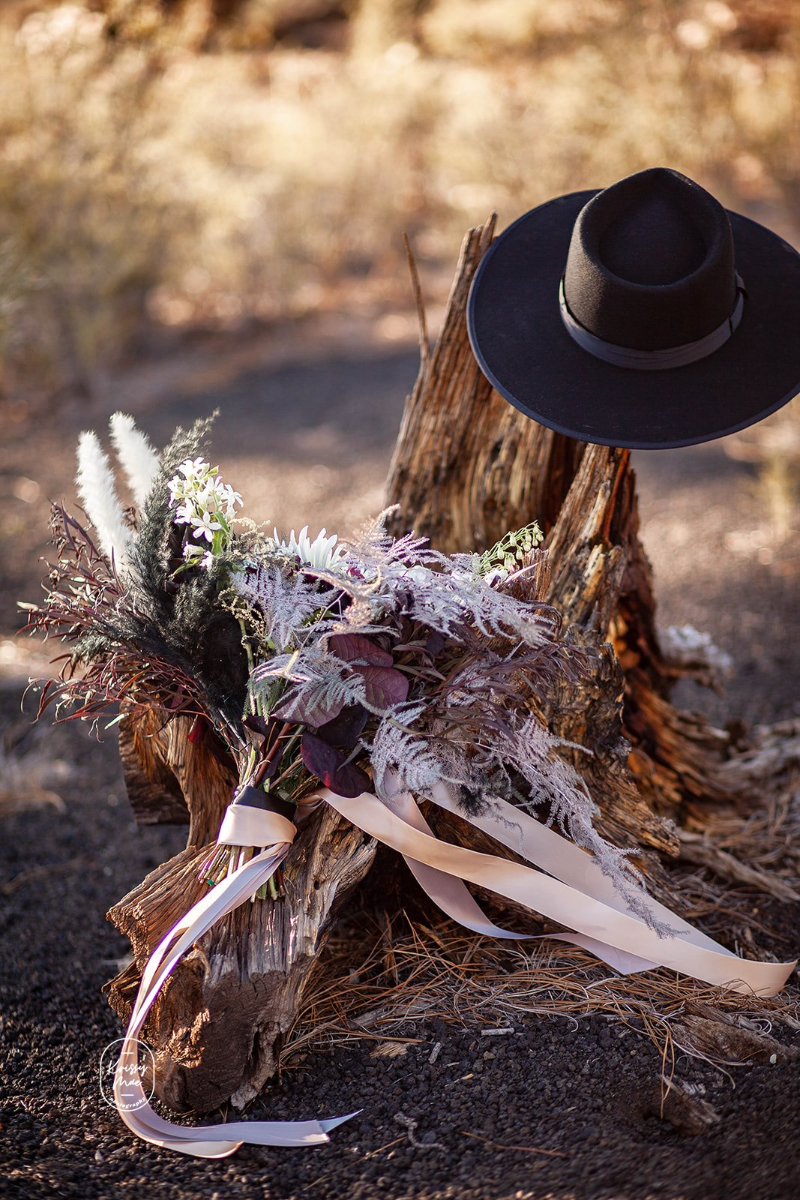 Desert elopement details - hat, bouquet, wood, desert