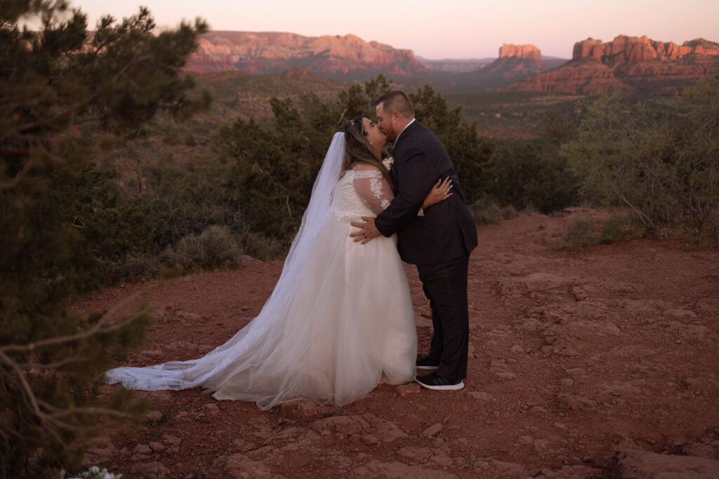 bride and groom kissing during sedona sunset